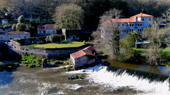 Aerial View Of Former Water Mill on the Tambre River With Water Cascading Down. Circle Dolly alt