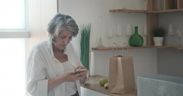 Senior Woman Received Delivery of Groceries in Paper Bag