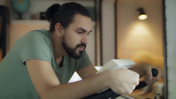 Fitness Man on a Bicycle Doing Spinning at the Gym alt