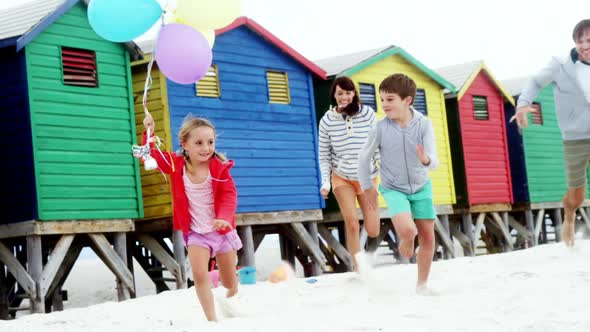 Happy family running at beach alt