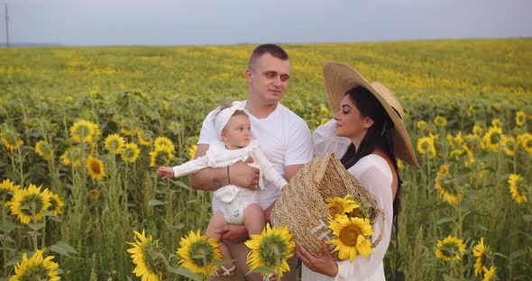 A Family With A Baby On A Photo Shoot In A Sunflower Field