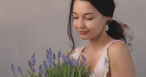 Woman Holding Bouquet of Flowers in Hands Indoors alt
