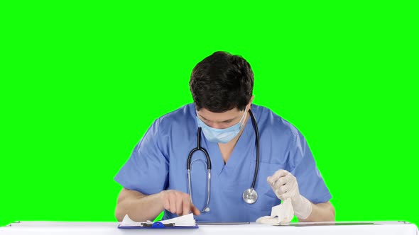 Doctor Removes Medical Gloves and Using Laptop alt