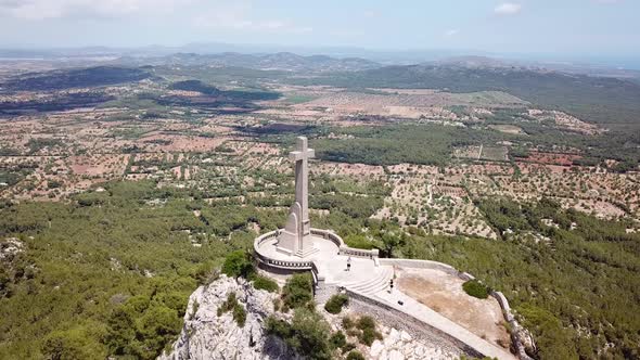 Aerial: The Holy Cross on the mountain of Saint Salvador in Mallorca, Spain alt