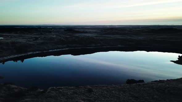 Blue Sky Reflecting in Western Ocean Surrounded By Sandy Shores alt