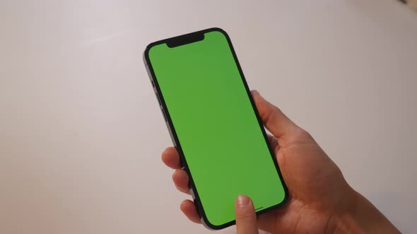 The Girl Touches the Green Screen of the Smartphone with Her Fingers