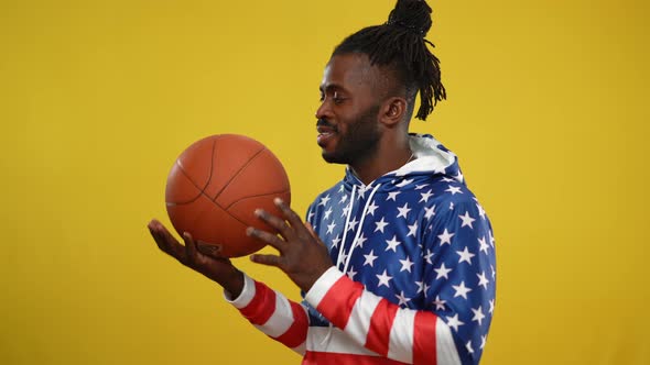 Smiling Successful African American Basketball Player Posing at Yellow Background alt