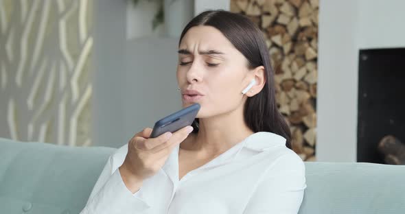 Young Smiling Woman Recording Audio Message to Friend alt