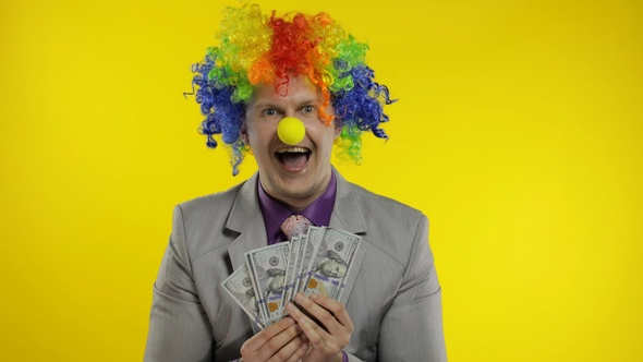 Clown Businessman Entrepreneur Boss in Wig Shows Tricks with Money Banknotes alt