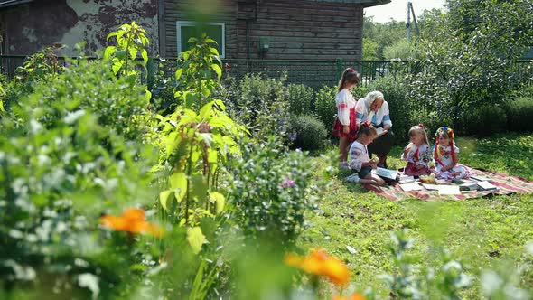 An Old Grandmother is Sitting on the Street and Reading a Book alt
