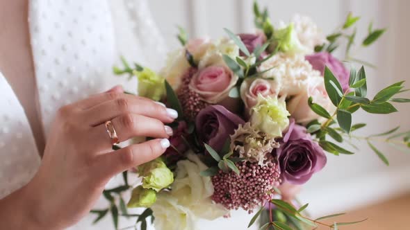 Closeup of the Bride Holding Her Wedding Bouquet She Gently Touches Flowers