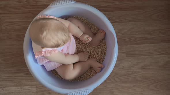 Cute baby girl in a round blue tub 1 alt