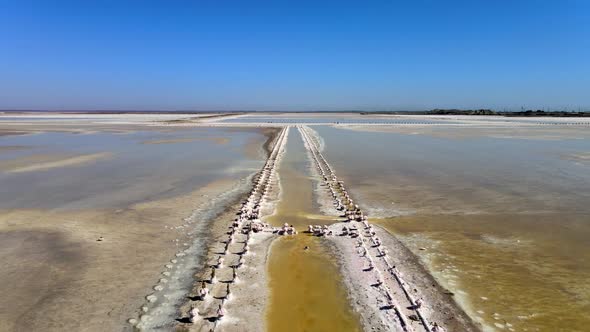 Abandoned Pier on Multicolored Lake Medicinal Clay Ungraded on Sunset, Air Drone View alt