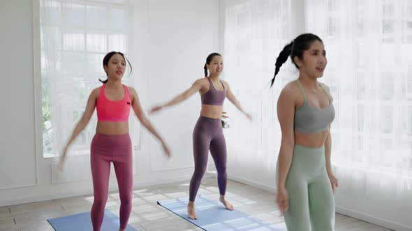 In the exercise class, girls Asians doing cardio exercises, they dance for fun to burn body fat.