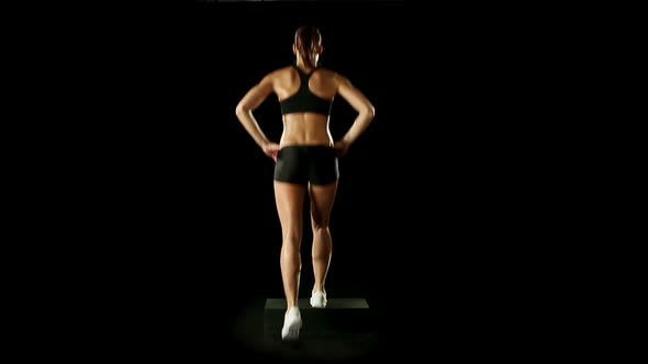 Young Athletic Woman Wearing Sporstwear is Exercising with Step Slow Motion Isolated on Black Loop