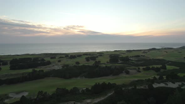Aerial view of sunset above Pacific Ocean and Bandon Dunes Golf Resort in Oregon, USA. Coastal lands alt