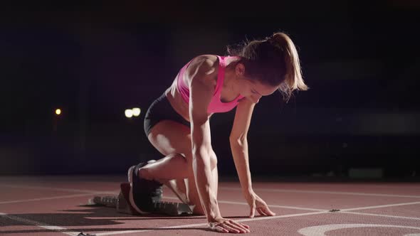 Woman Hand on Track As He Crouches in Starting Position at the Beginning of a Race alt