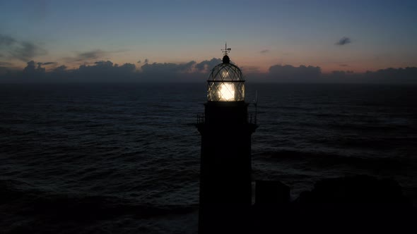 Lit Lighthouse at Dusk in Cape Vilan Galicia Spain Aerial View alt