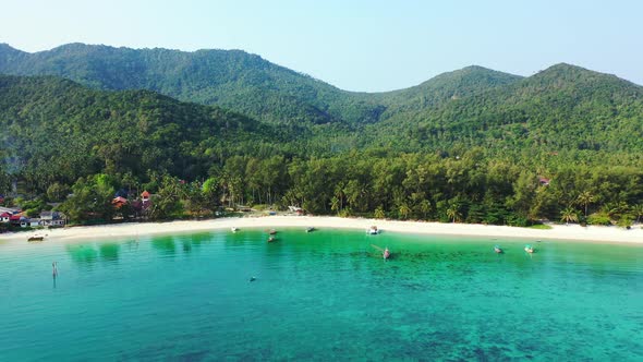 Beautiful fly over travel shot of a white sandy paradise beach and aqua blue ocean background alt
