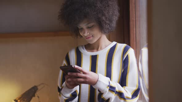 Mixed race woman texting at home alt