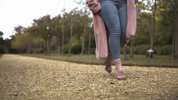 Curvy woman walking through the park and going down the stairs. alt