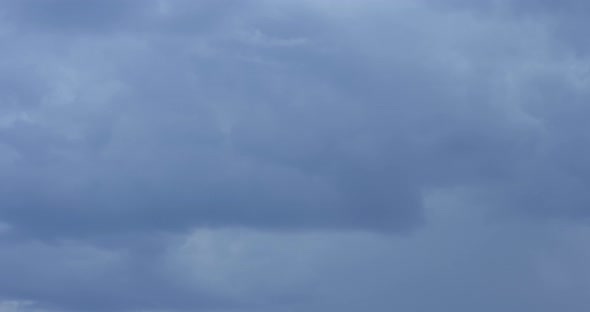 The motion of clouds on the background of the azure sky.