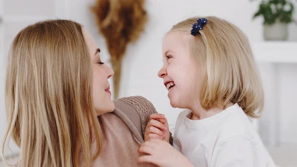 Portrait of Blonde Caucasian Woman Happy Mother Nanny Babysitter Hugs Little Daughter Baby Cute Girl alt