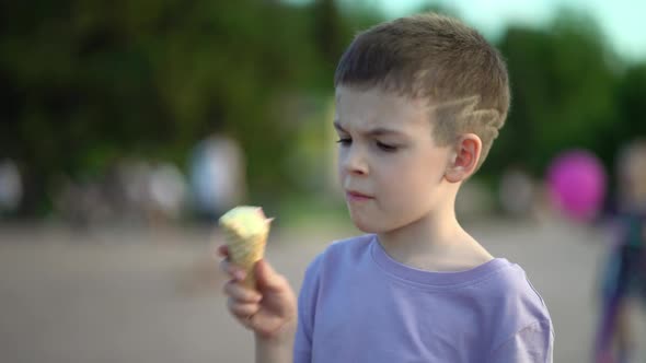 Portrait Boy Eating and Enjoying Cold Ice Cream in Waffle Cone
