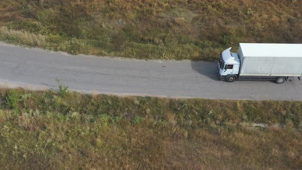 Aerial Shot of Truck with Cargo Trailer Driving on Road and Transporting Goods alt