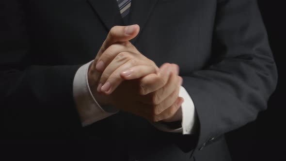 Businessman in a suit rubs hands