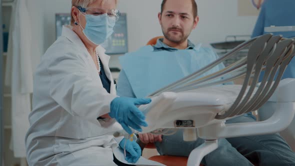 Mature Dentist Examining Patient with Caries and Toothache alt