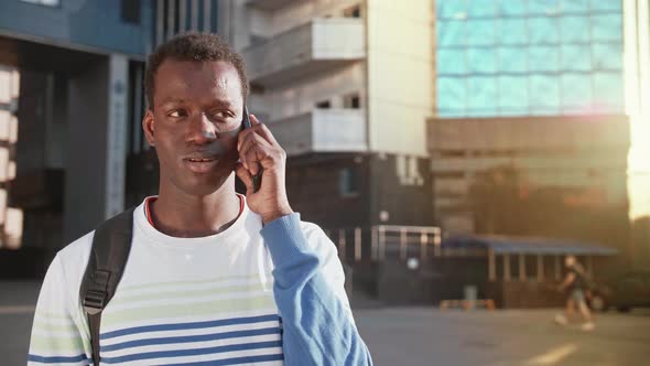 Portrait Joyful Happy Young Black Guy in Casual Clothes Talking on Smartphone Walk Street