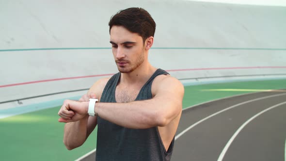 Man Doing Sport in Smart Watch at Stadium. Happy Runner Tracking Result alt