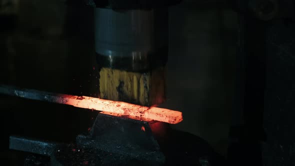 Hydraulic Hammer Shaping Piece of Hot Iron. Blacksmith Forges Red-hot Metal in Workshop alt