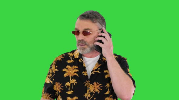 Senior Traveler in Sunglasses Walking and Making a Call on a Green Screen Chroma Key alt