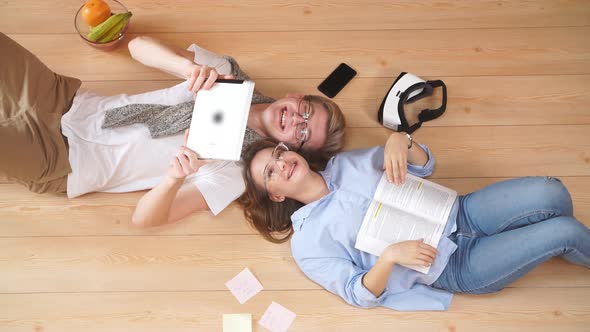 Loving Young Couple Spending Time Together and Resting at Home Lying on the Floor.