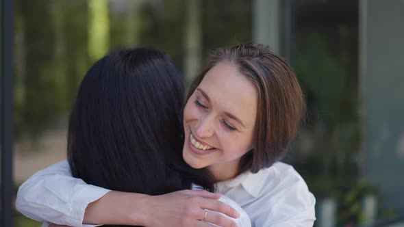 Happy Woman Hugging Friend Smiling Looking at Camera in Slow Motion alt