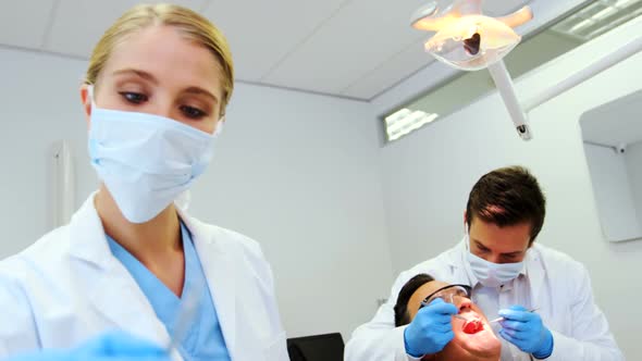 Dentists giving anesthesia to male patient alt