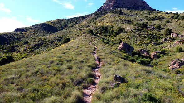 Calblanque coast aerial drone shot of hiking sportsmen walking in mountain alt