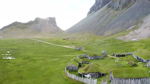 Greenery Landscape With Traditional Wooden Houses In Viking Village At Vestrahorn Mountain, Iceland. alt