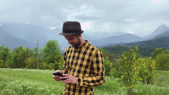 Man holding smart phone in landscape