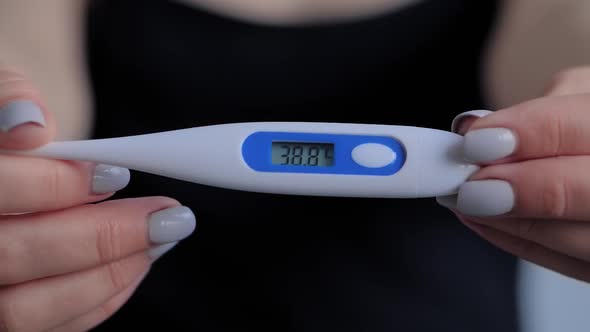 Slow Motion: Woman Holding Digital Medical Thermometer with High Temperature