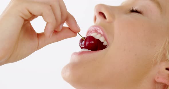 Clos-up of beautiful woman eating cherry alt