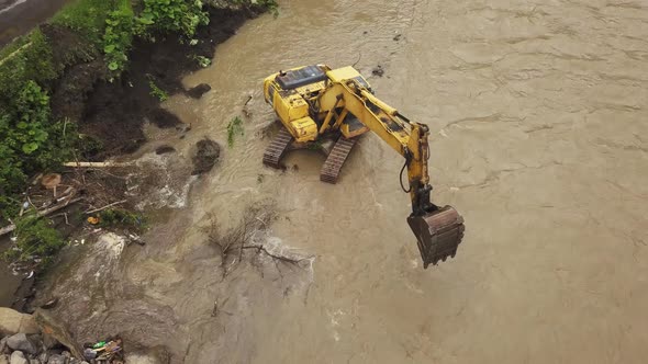 Yellow dredge Excavator working in the mountain river, scooping excavator bucket. Extracting gravel