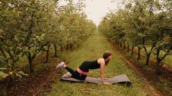 Young Woman Working Out Resistance Bands in Sportswear Outdoors alt