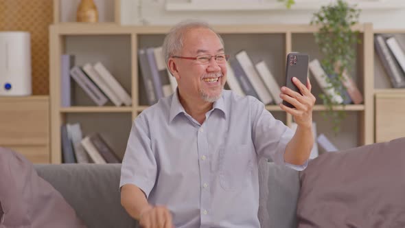 Asian elderly man making video call on smart phone, online call,  digital technology service consult alt