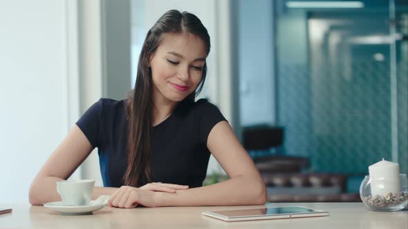 Pretty Young Woman Drinking Tea and Flirting in a Coffee House alt