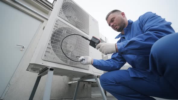The technician uses a digital camera to check the clogging of the heat exchanger alt