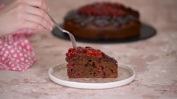 Piece of Homemade Delicious Cherry Chocolate Cake Taking Piece with Fork