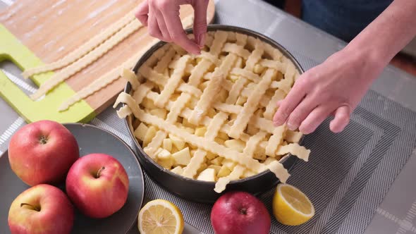 Apple Pie Preparation Series Woman Covering Baking Dish Full of Chopped Apples with Stripes of alt